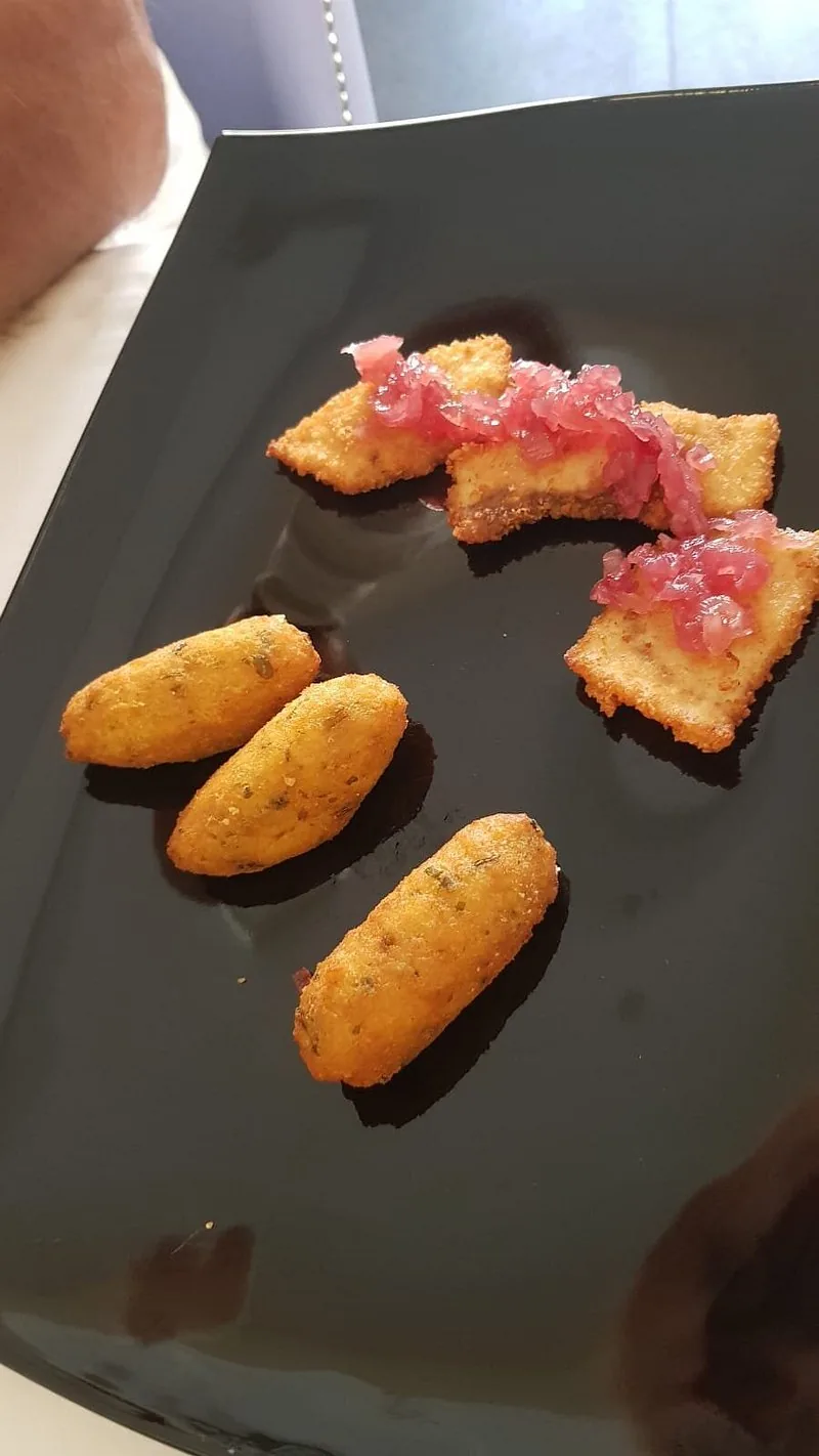 Tartare e bocconi croccanti su piatto nero · Kairos, Crotone